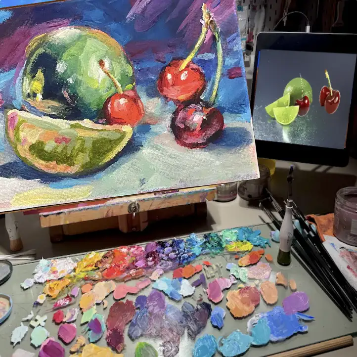 Artist workspace showing expressive still life painting of cherries and lime with vibrant hand-mixed palette and reference image on screen